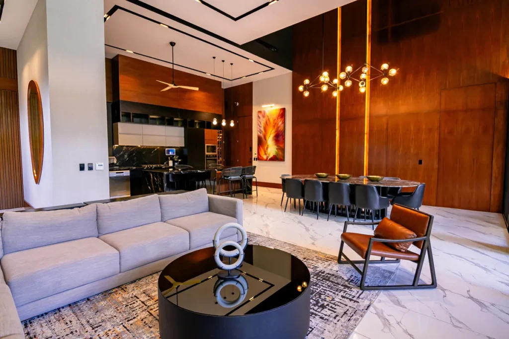 Diseño interior Casa Verona: Sala principal a doble altura con acabados en madera de Tzalam y granito. 553 m² de construcción superior a los terrenos Yucatán.